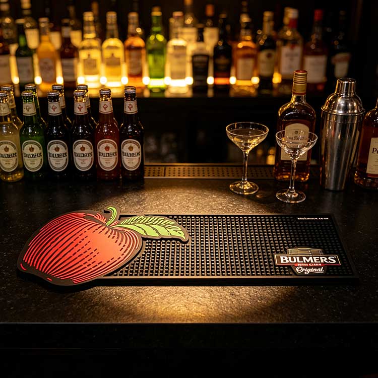 Custom Logo Bar Mat with Cider Bottles and Cocktail Glasses in Premium Bar Setup custom logo rubber bar mat premium bar display cider bottles spirits cocktail glasses pub counter mat